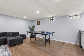 A room with a pool table, a grey sofa, and a small plant. - Spacious house Rockford (Rockford)