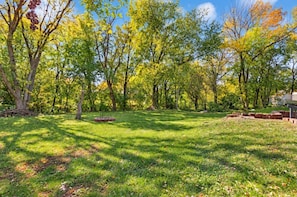 A grassy outdoor area with trees and a brick structure. - Spacious house Rockford (Rockford)