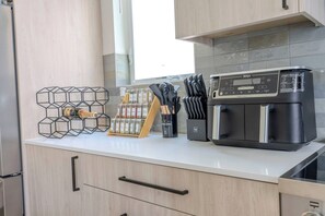Eine Küche mit integriertem Kaffeeautomaten, einer Gewürzleiste und einem Besteckhalter.