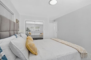 A bedroom with a bed, a wardrobe, and a mirror. - McGregor Oasis: 4BR/ 5BTH Private Pool & Game Room (Fort Myers)