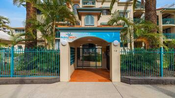 A hotel entrance with a sign reading 'Aloha Beach Resort.'