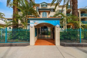 A hotel entrance with a sign reading 'Aloha Beach Resort.'