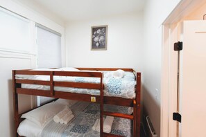 A bunk bed with white bedding and a framed floral picture on the wall. - North Beacon Hill Seattle Retreat, Sauna, Jacuzzi Tub, King Bed, Central Locale! (Seattle)