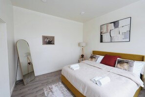 A hotel room with a bed, a mirror, a lamp, and a painting on the wall. - North Beacon Hill Seattle Retreat, Sauna, Jacuzzi Tub, King Bed, Central Locale! (Seattle)