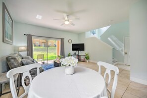 A living room with a dining table, chairs, a sofa, a TV, and a ceiling fan. - Spacious Resort Home with 2 Master Bedrooms - Near Disney & Universal Studios (Davenport)