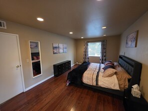A bedroom with a bed, dresser, and a window with curtains. - Versatile Fully Furnished 2 Bed/2 Bath Condo near Anschutz, Buckley SFB, and DIA (Aurora)