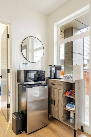A compact kitchen with a stainless steel refrigerator, microwave, and coffee maker. - Modern Spacious 1-BR Automated Haven: Work-Ready - Private Room in Townhome (Seattle)