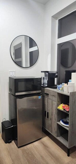 A compact kitchenette with a microwave, coffee maker, and a refrigerator. - Modern Spacious 1-BR Automated Haven: Work-Ready - Private Room in Townhome (Seattle)