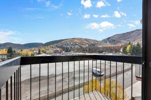 A view from a balcony overlooking a parking lot with a mountain in the background. - Shadow Ridge 4123: Corner Unit, Walk to Ski -2Bedroom, 3 bath (Park City)