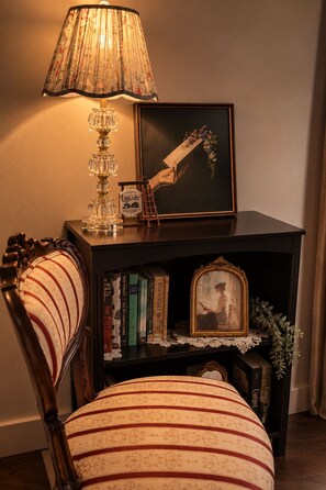 A bookshelf with books, a framed picture, a lamp, and a decorative item. - Luxury Storybook Suite with Mountian Views. (Abbotsford)