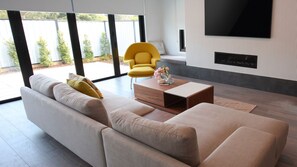 A modern living room with a sofa, a yellow chair, and a coffee table. - Daylesford Scandinavian Chalet (Daylesford)