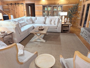 A cozy living room with a sectional sofa, a coffee table, and a fireplace.