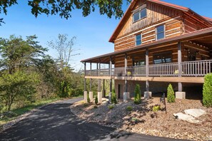 A two-story log cabin with a balcony and a stone foundation. - Blacksburg Cranberry Lodge - VT Luxury Retreat (Blacksburg)