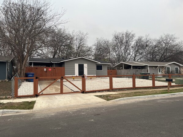 A residential area with a gated driveway, a house with a garage, and a mailbox. - 3-bedroom house close to Lackland AFB, Seaworld and Downtown San Antonio (San Antonio)