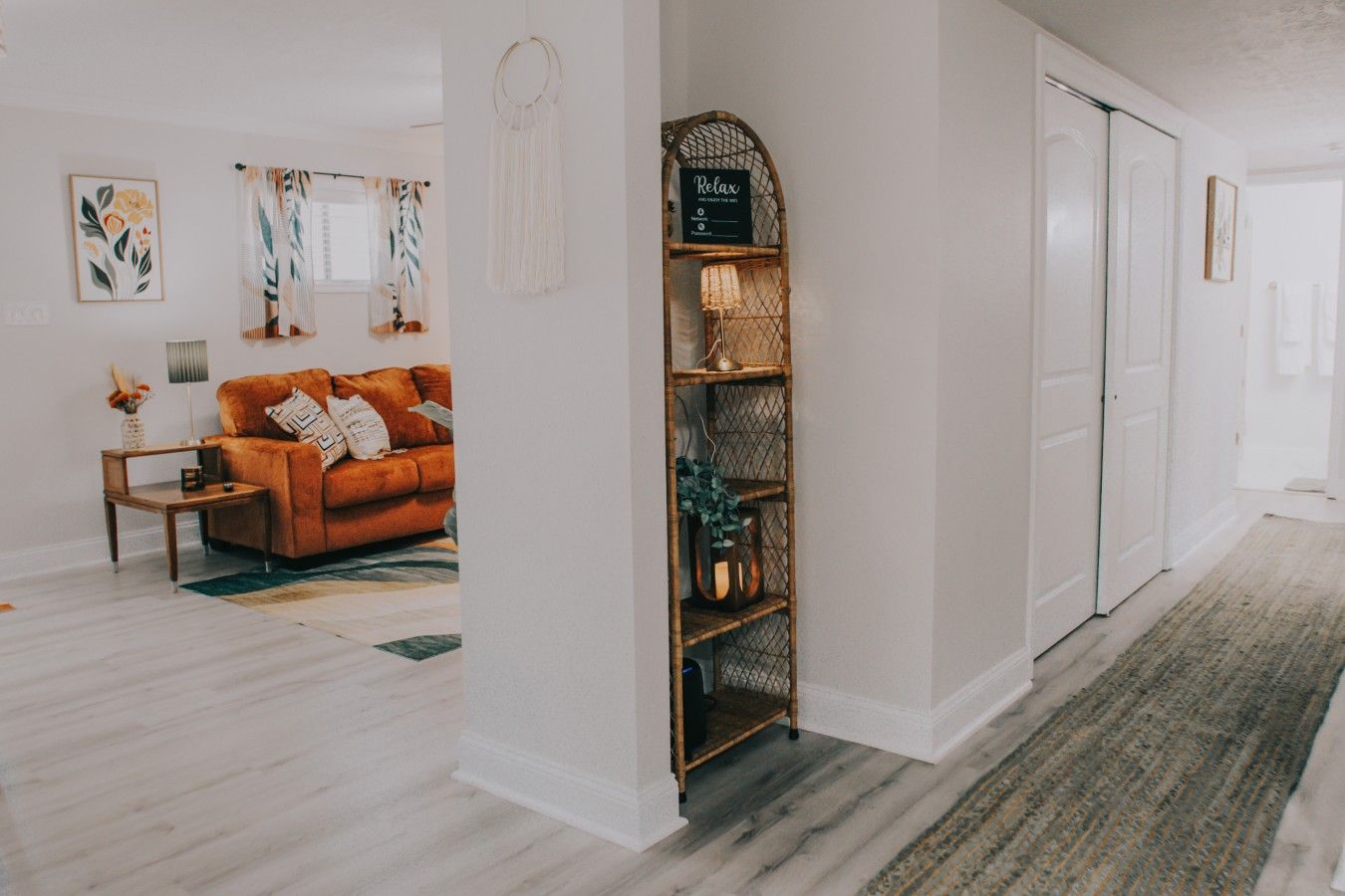 A hallway with a sofa, a bookshelf, and a door.