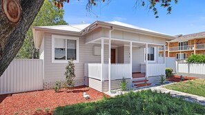 A single-story house with a covered porch, a fenced yard, and a small garden area. - The White Honey Cottage - Newly Renovated 4BDR on White Street (West Tamworth)