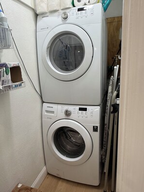 Une machine à laver et un sèche-linge Samsung à chargement frontal, superposés dans une buanderie.