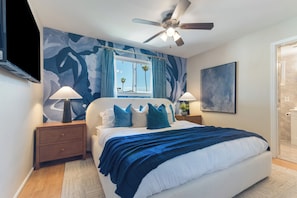 A bedroom with a bed, two nightstands, a ceiling fan, a window with curtains, and a wall-mounted TV. - Private pool paradise w/ping pong, foosball & outdoor fire pit! (Tempe)