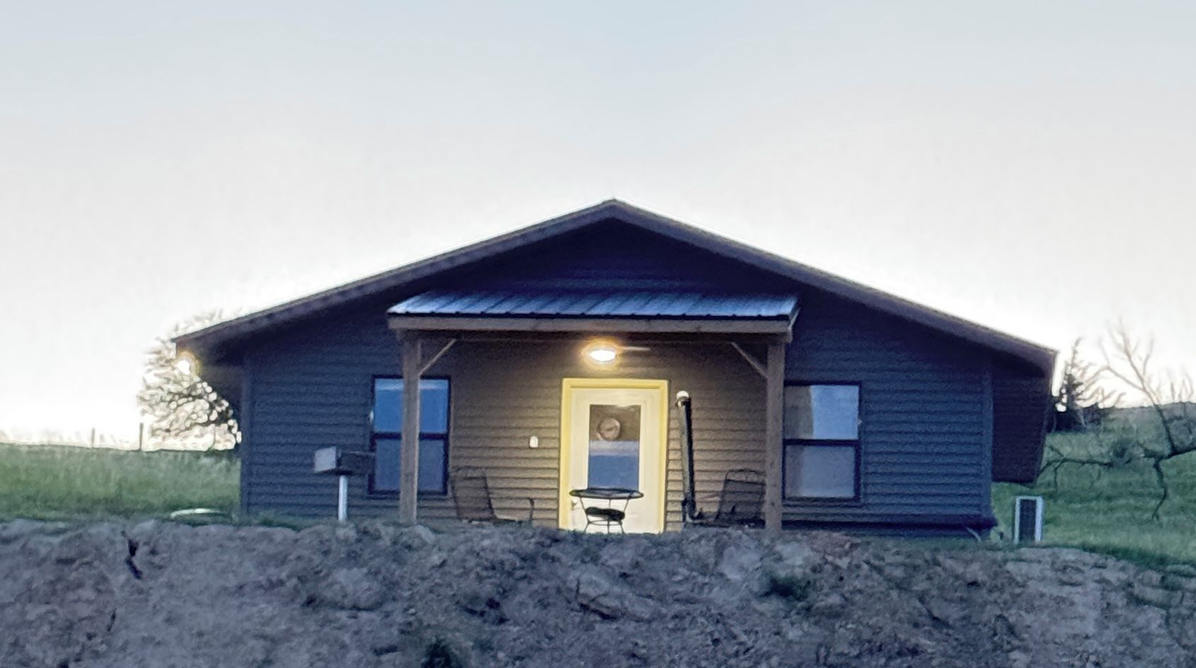 A single-story building with a gabled roof, a front door, and a small porch area.