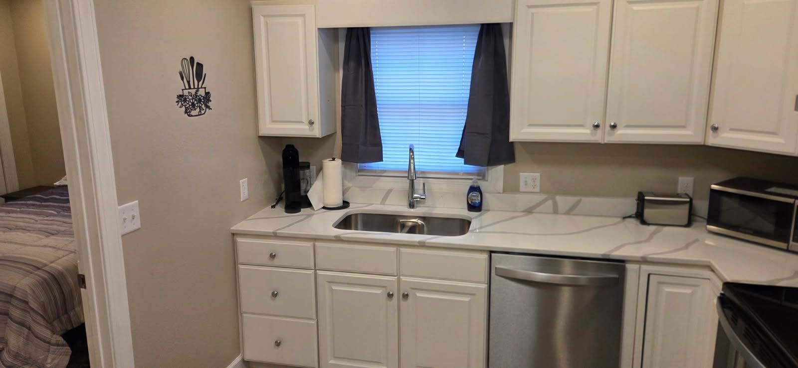 A compact kitchenette with a sink, a coffee maker, a toaster, and a microwave.