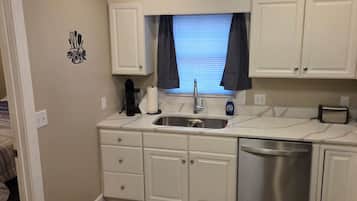 A compact kitchenette with a sink, a coffee maker, a toaster, and a microwave.