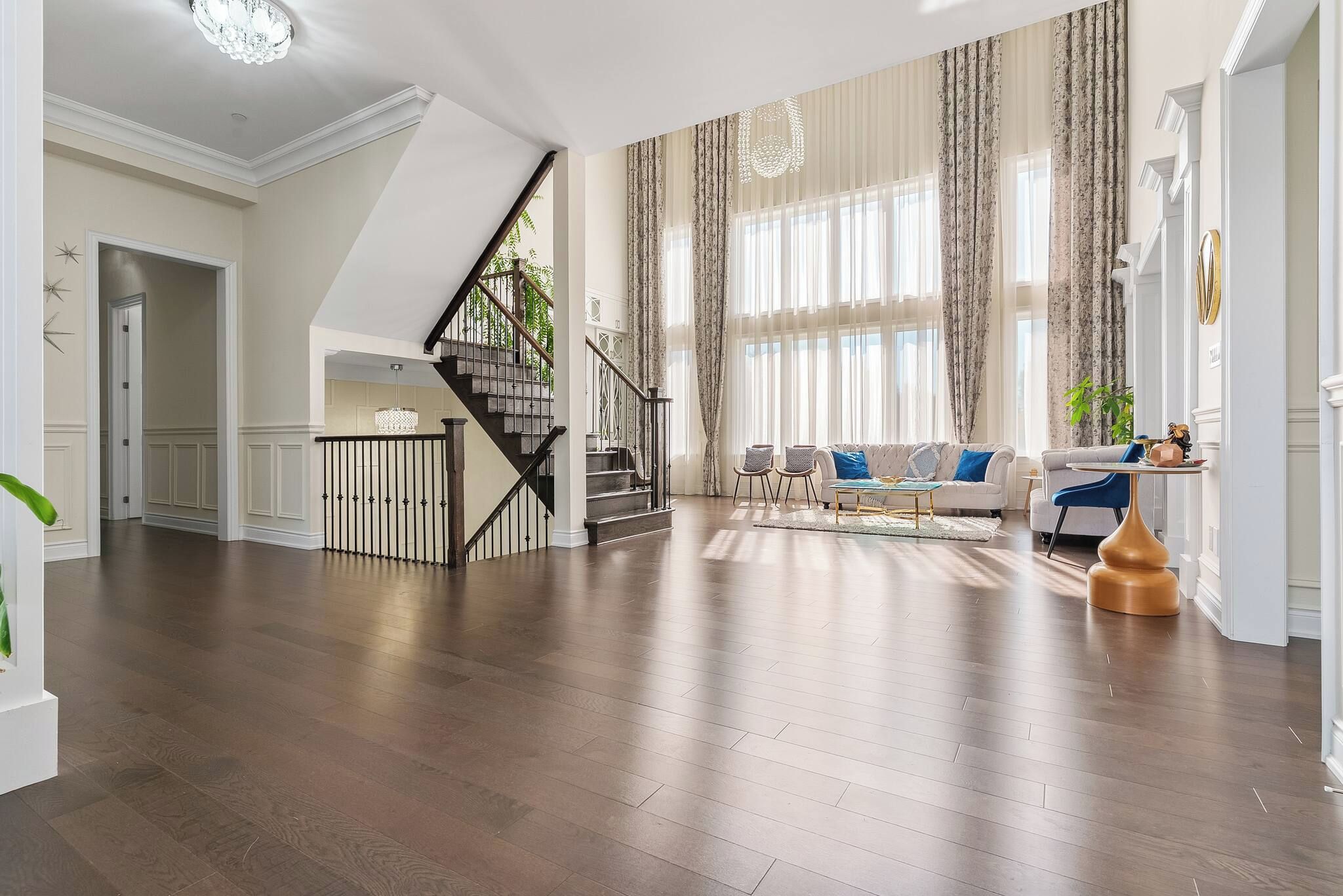 Un salon spacieux avec un escalier, un ensemble de canapés et une table basse.