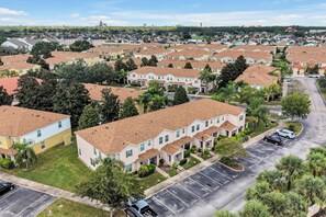 A residential area with multiple-story houses, a parking lot, and a clear sky. - Family Villa Near Disney, Pool & 2 Suites (Kissimmee)