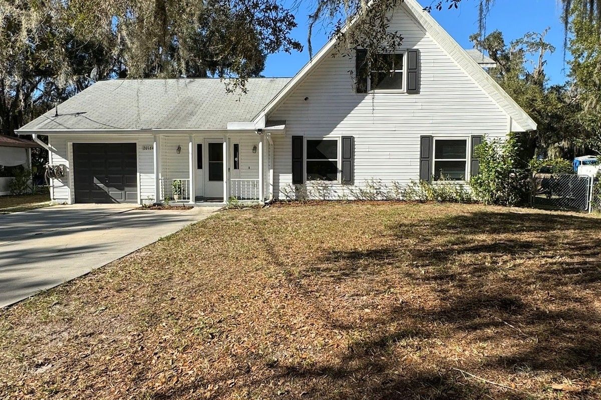 A single-story house with a garage, a covered porch, and a well-maintained lawn.