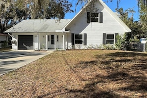 A single-story house with a garage, a covered porch, and a well-maintained lawn.