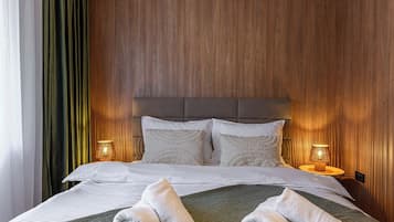 Soft sage and warm wood tones create a soothing bedroom palette — layered pillows, upholstered headboard and bedside lighting for a premium mountain stay. Slopeview Chalet.