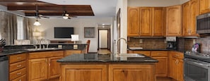 A kitchen with wooden cabinets, granite countertops, a stainless steel sink, and a built-in oven. - Disney in Luxury! Spring Break 3/13-3/16. Rare RESORT find. For 4. Full Kitchen (Lake Buena Vista)