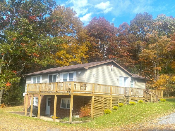 A two-story house with a balcony, a covered porch, and a small front yard. - Lovely 5-bedroom / 2 Bathroom / Pet-friendly (McHenry)