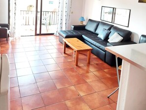 A living room with a black sofa, a wooden coffee table, and a white table. - MAREVERDE WIFI FREE & POOL VIEW (Costa Adeje)