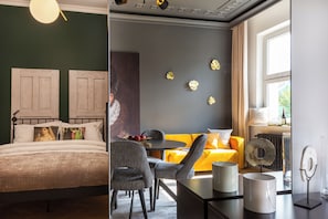 A room with a bed, a dining table with chairs, a sofa, and a window with curtains. - Eclectic 2-bed apartment by Fragola (Kraków)
