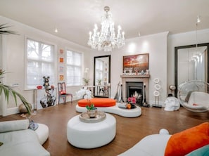 A modern living room with a fireplace, white furniture, and decorative items. - The Chelsea Town House (London)