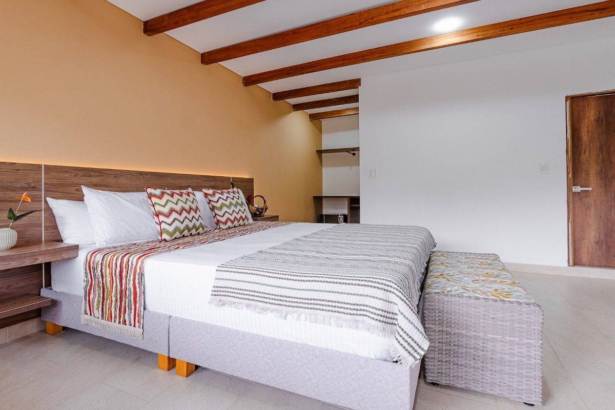 A bedroom with a bed, bedside tables, and a wardrobe.