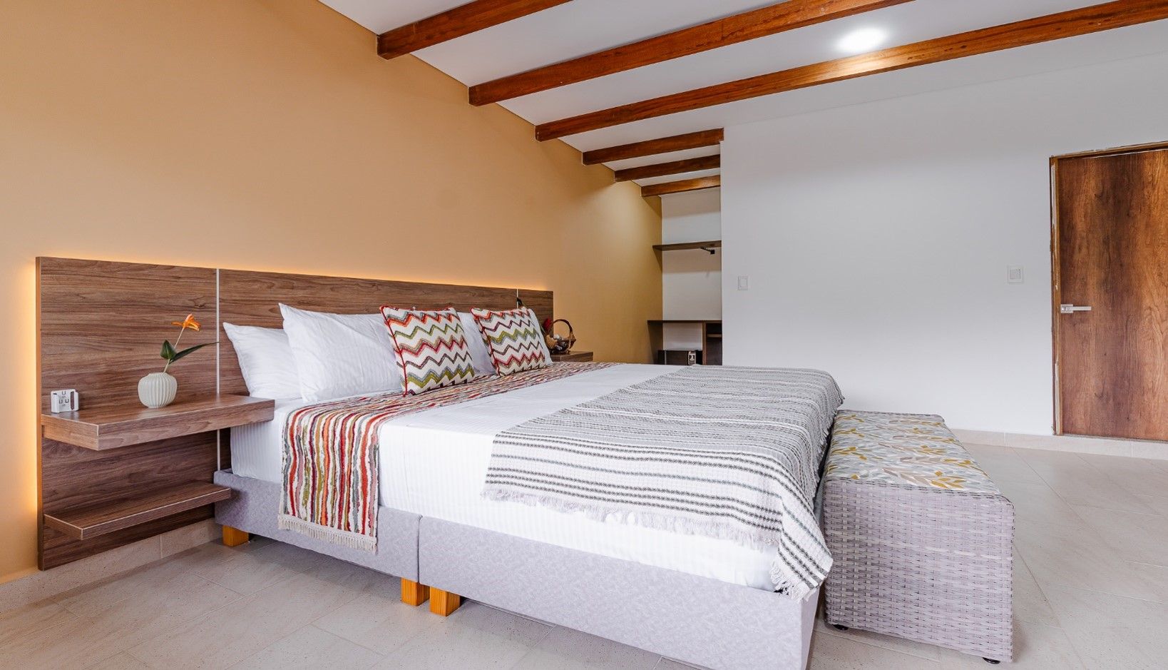Un dormitorio con cama, mesitas de noche y un armario.