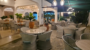 A spacious indoor seating area with wicker furniture and potted plants. - Hotel Santa Inés (Villavicencio)