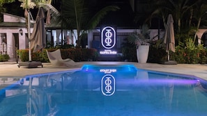 A hotel pool area with a sign for 'SANTA INES HOTEL' and a logo for 'SEVILLA HOTEL'.
