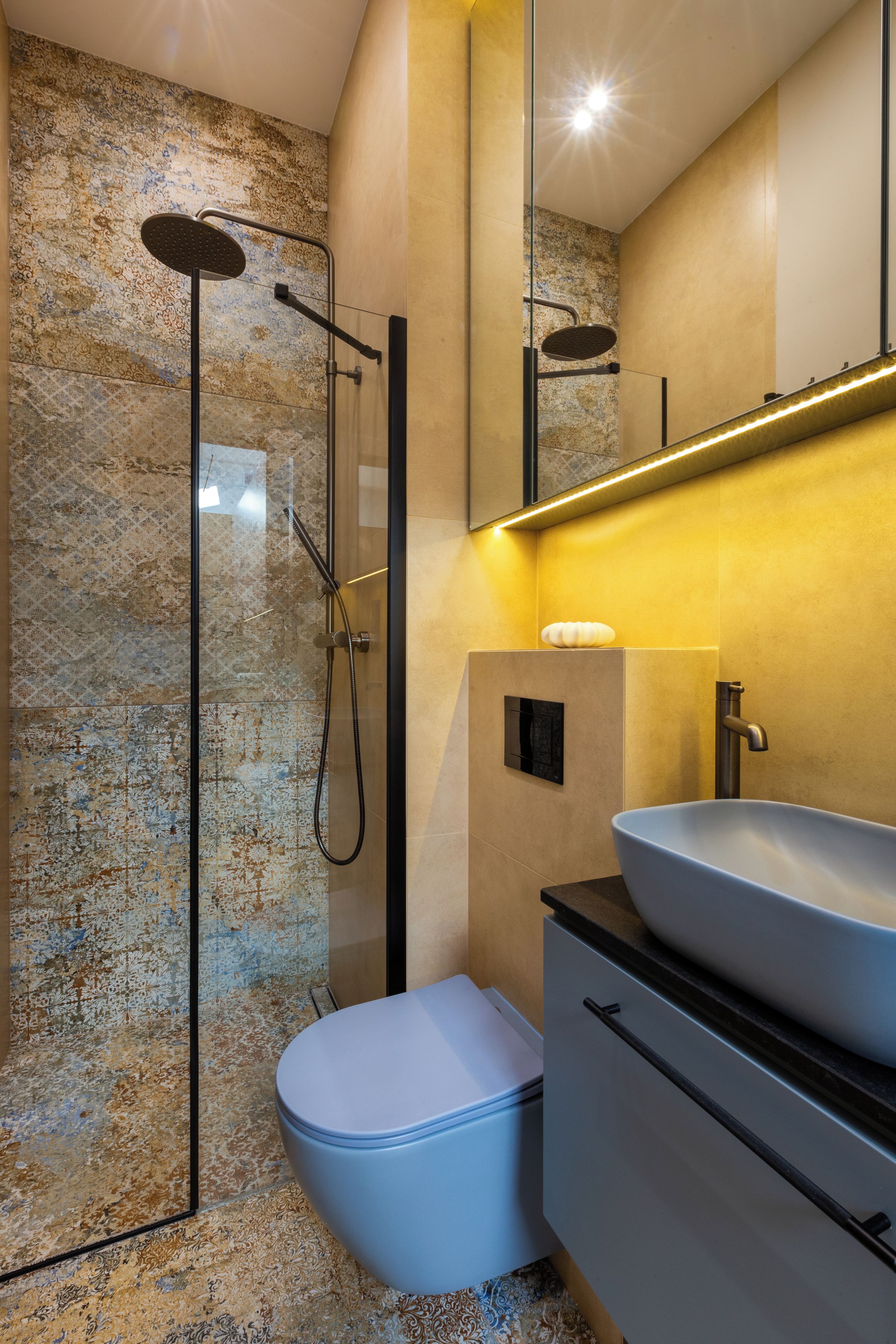 A bathroom with a glass-enclosed shower, a white toilet, and a sink with a vessel basin.