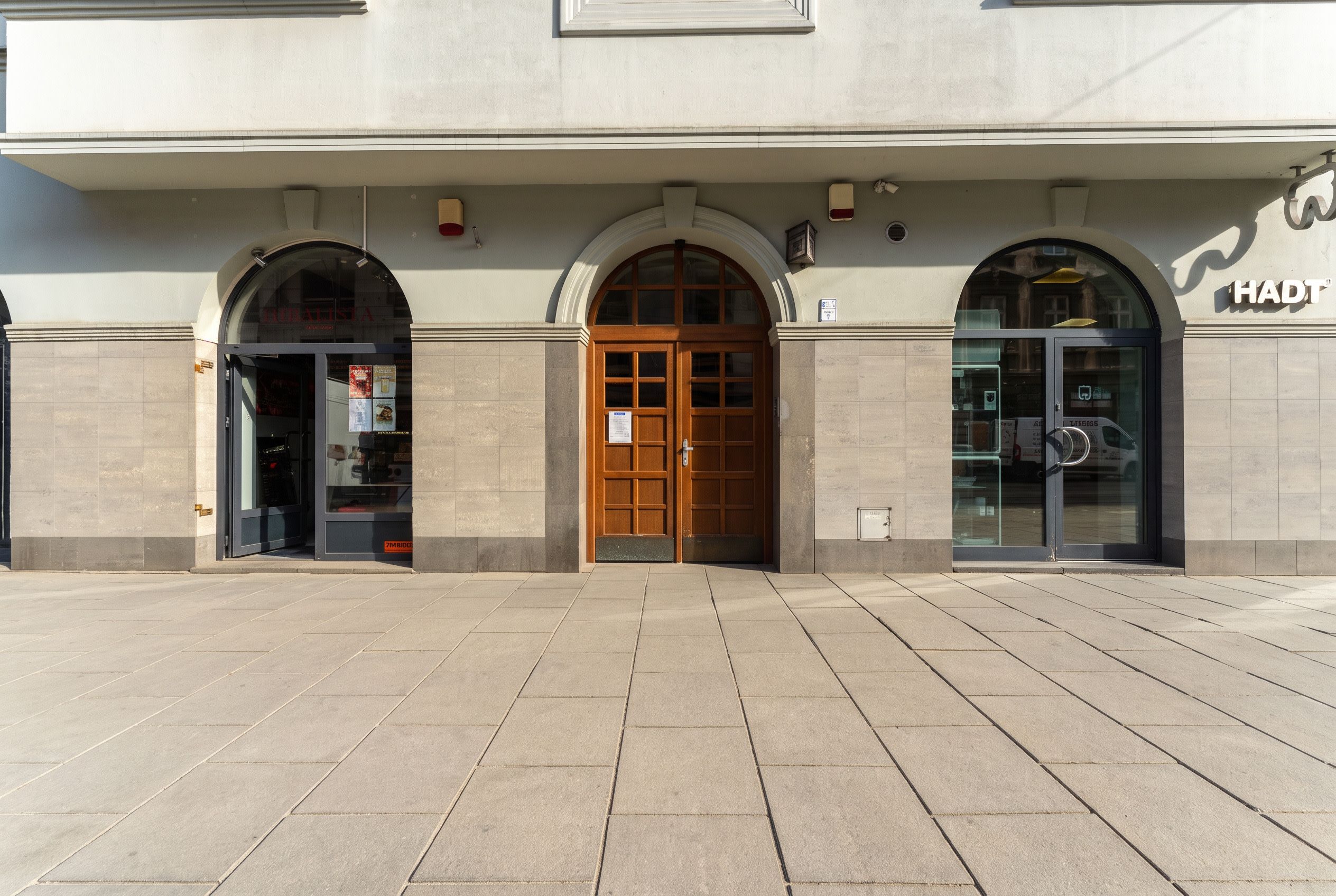 Un bâtiment doté d’une grande entrée en arc de cercle, d’une porte vitrée sur la droite et d’une enseigne indiquant « HADT ».