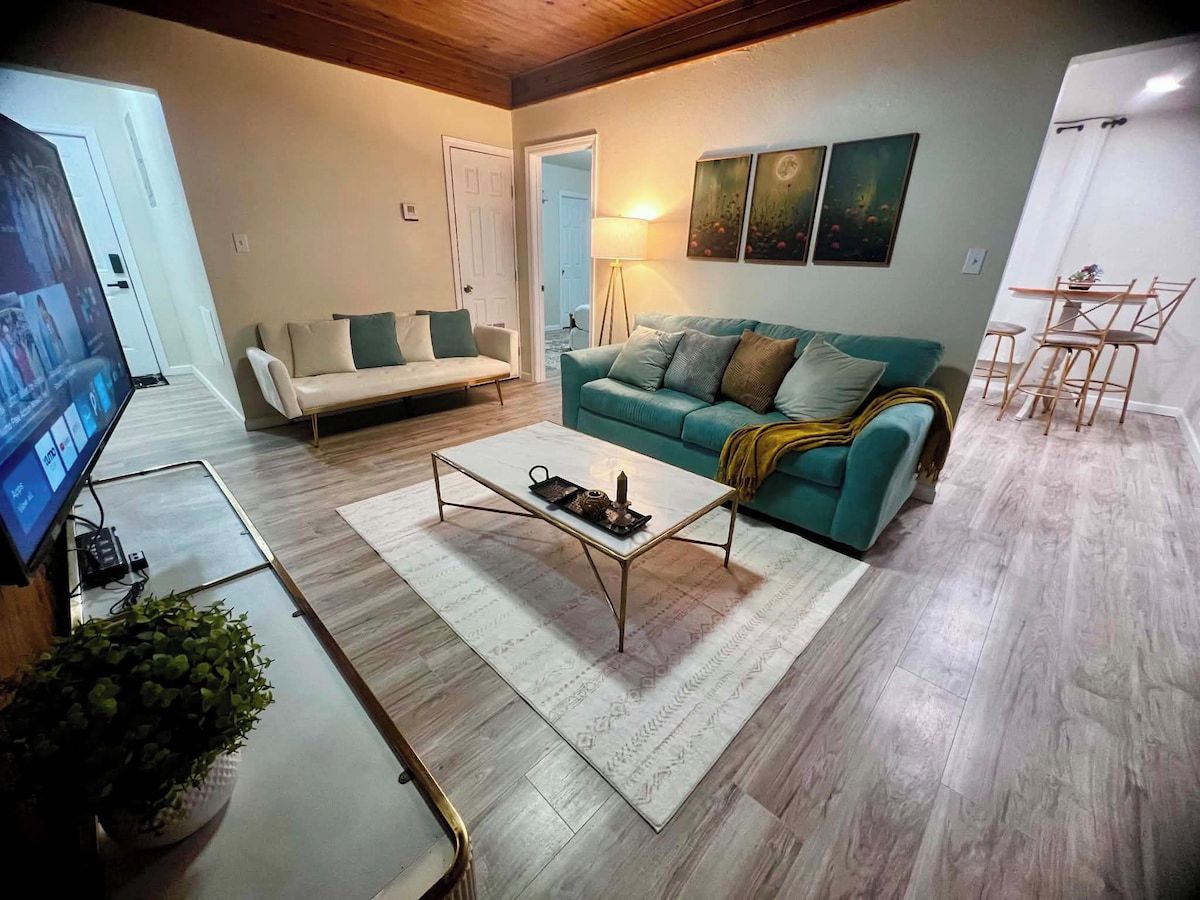 A living room with a sofa, a coffee table, and a television.
