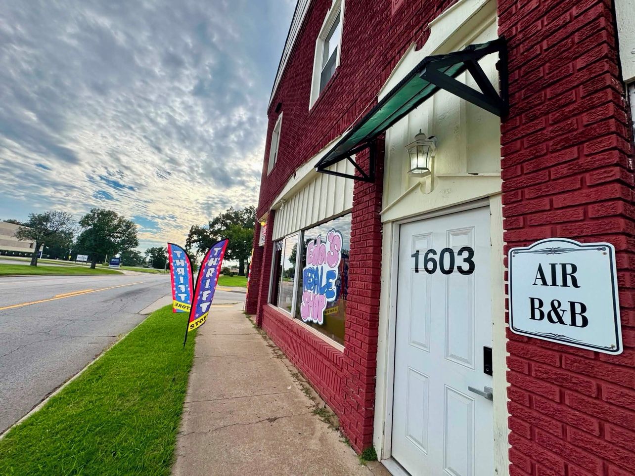 A red brick building with a white door labeled '1603' and a sign 'AIR B&B'.