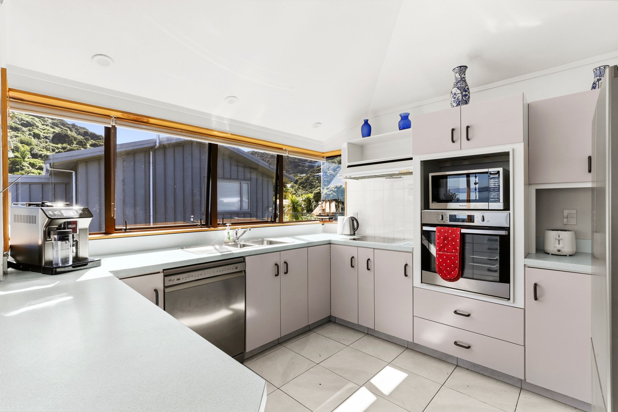 A modern kitchen with a dishwasher, oven, and a coffee machine.