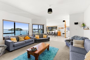 A spacious living area with large windows, a dining area, and a kitchen. - Beachfront Home at Tata Beach (Tata Beach)