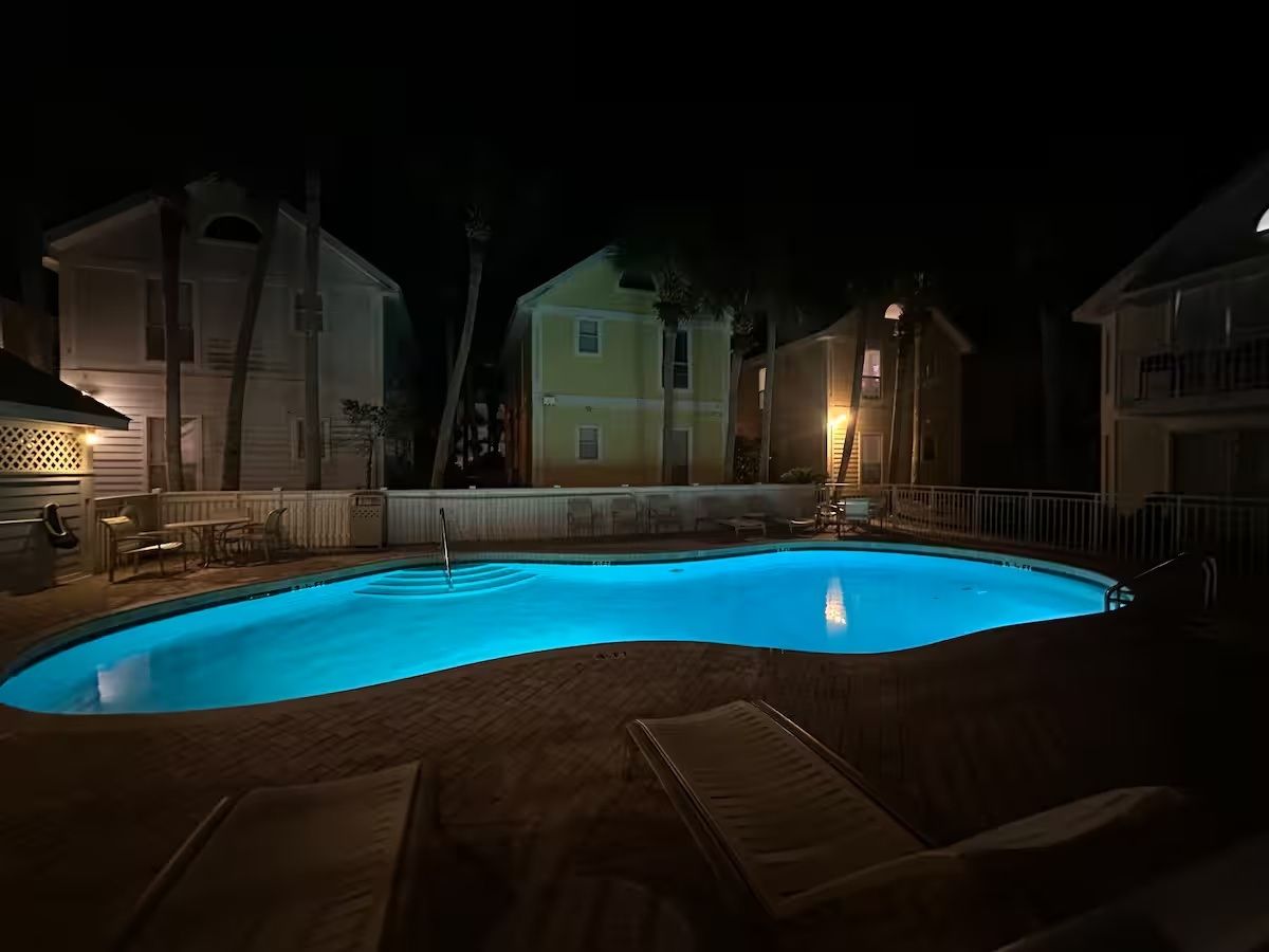 Une piscine illuminée de bleu la nuit.