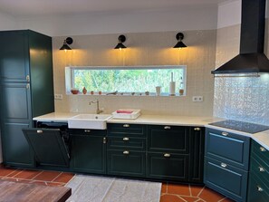 A kitchen with a window, a sink, cabinets, and a stove. - 4-bedroom house in Melides with an outdoor hot tub. (Melides)