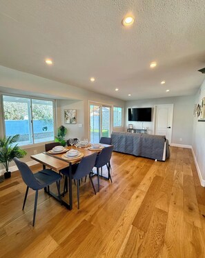 A spacious dining area with a wooden table set for six, surrounded by chairs. - Luxury Scenic Retreat, Spacious Home, Elegant Comfort & Stunning Views (Santa Clarita)