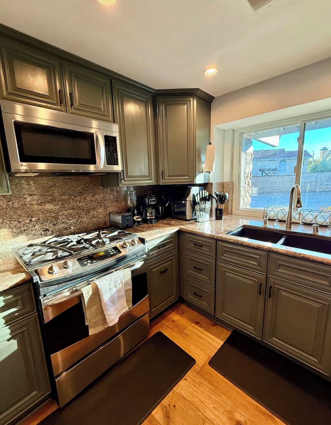 A modern kitchen with a stainless steel stove, microwave, and coffee maker.
