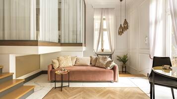 Uma sala de estar moderna com sofá, mesa de centro e uma área de jantar com mesa e cadeiras.